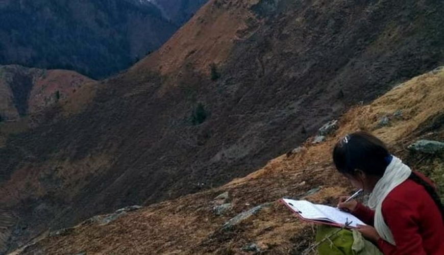 A girl takes an online exam on the top of a mountain in Bharmour, Chamba, HP