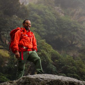 Trek leader standing on a rock during a Himalayan adventure in Himachal Pradesh
