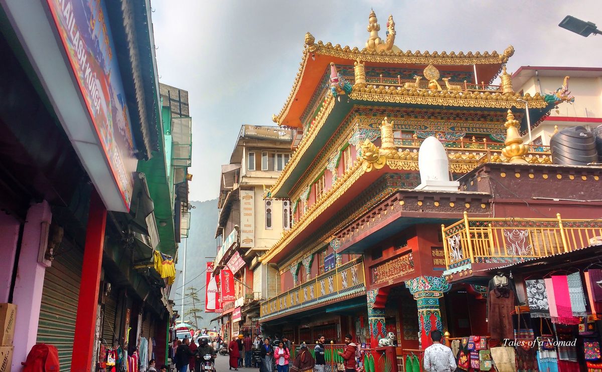 Colorful Tibetan monastery and busy market street in McLeod Ganj, Dharamshala, Himachal Pradesh.