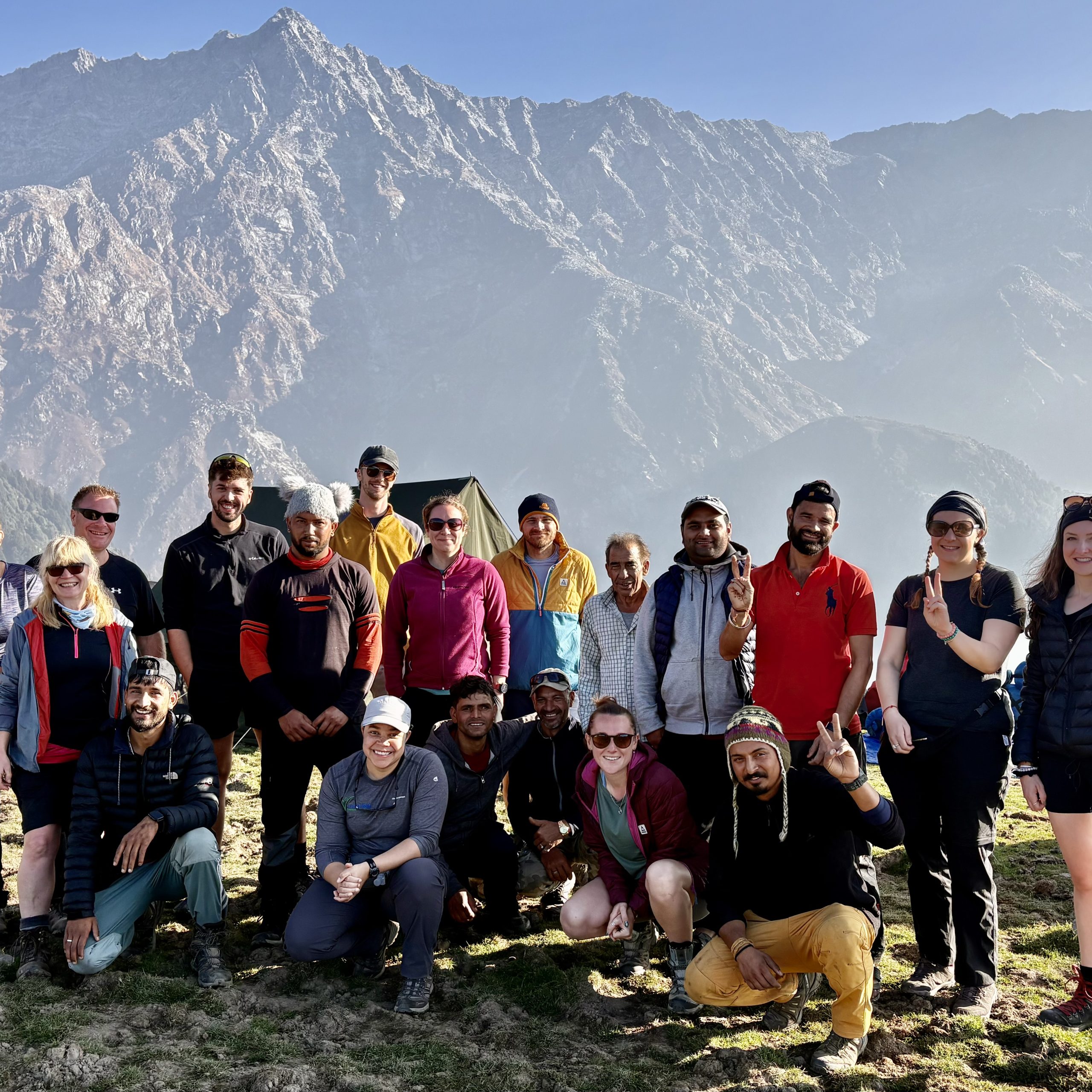 Group of trekkers posing at a scenic mountain viewpoint during a Himalayan trek